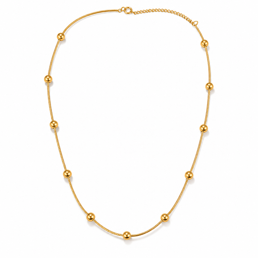 Gold beaded snake chain necklace on white background
